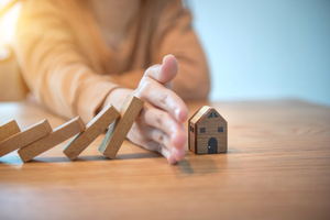 dominoes falling on a model house